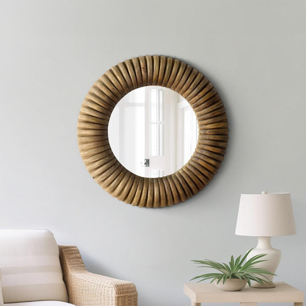 Round mirror with wooden frame, cozy chair, lamp, and plant on side table.