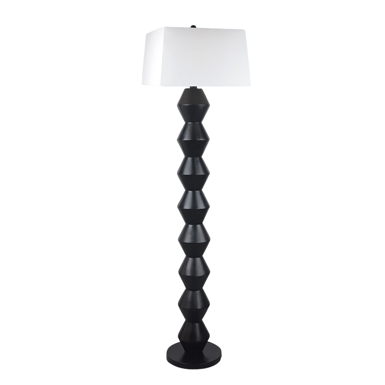Modern floor lamp with geometric black base and white shade.