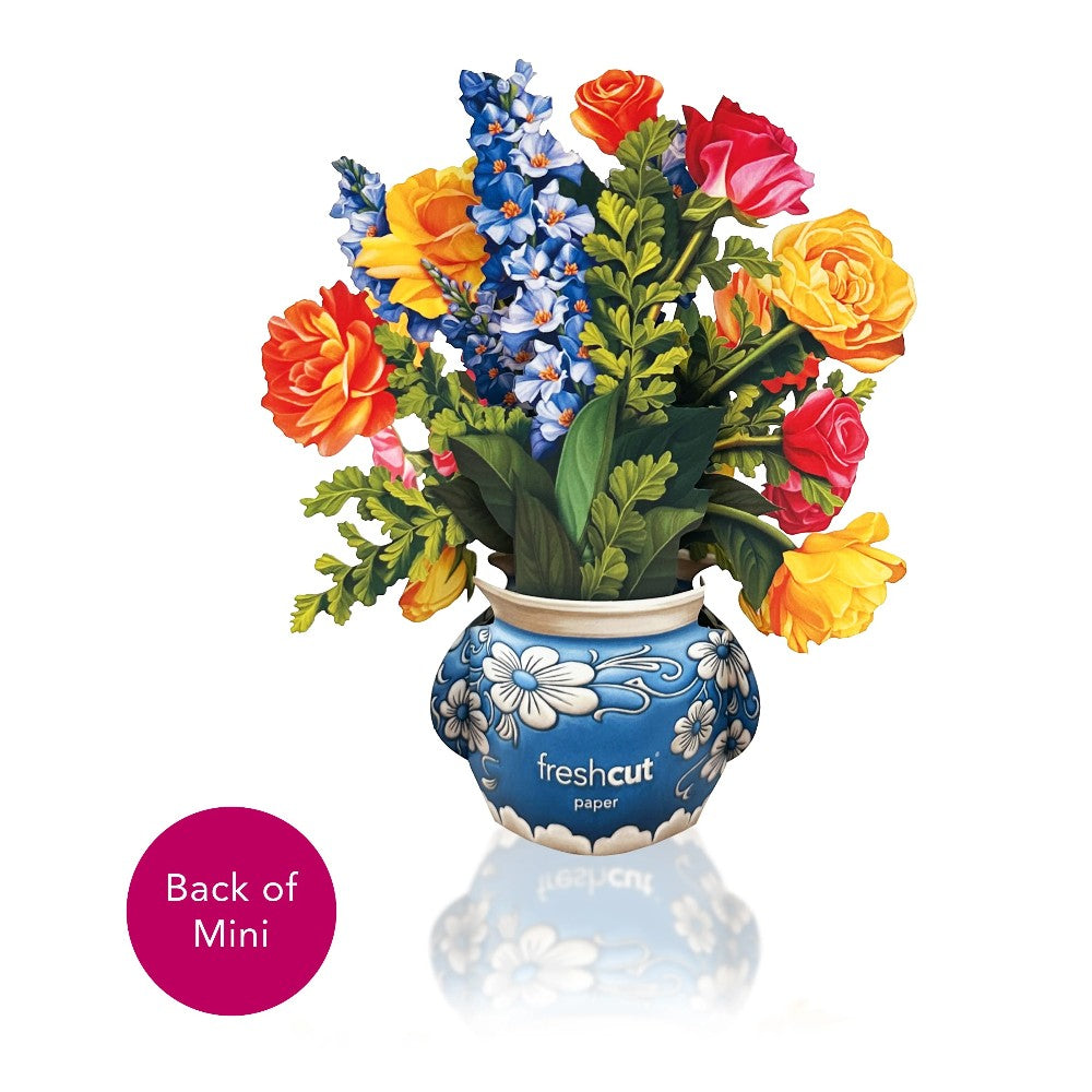 Vibrant paper flowers in a blue patterned vase.