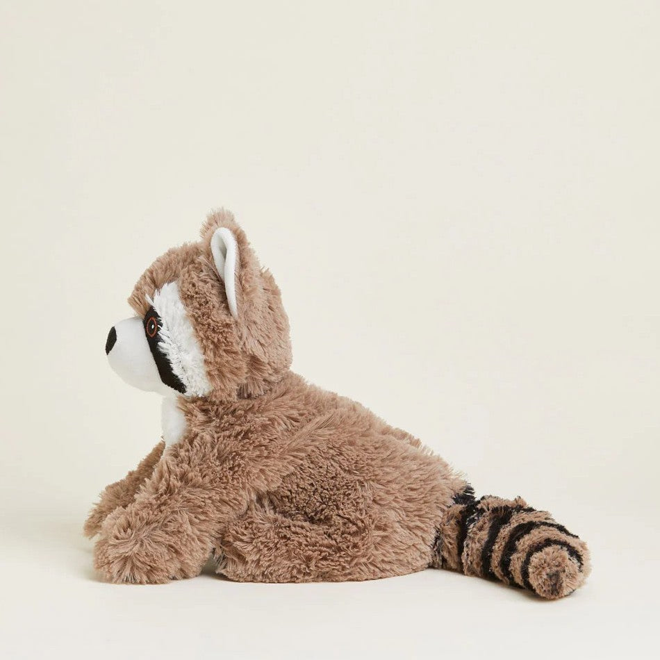 Fluffy raccoon plush toy sitting on a plain background.