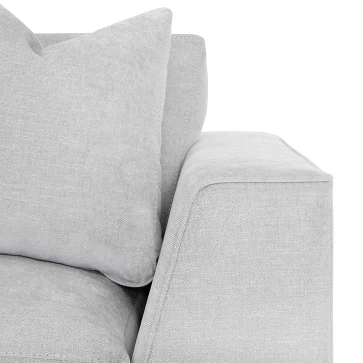 Light gray sofa corner with plush cushions.