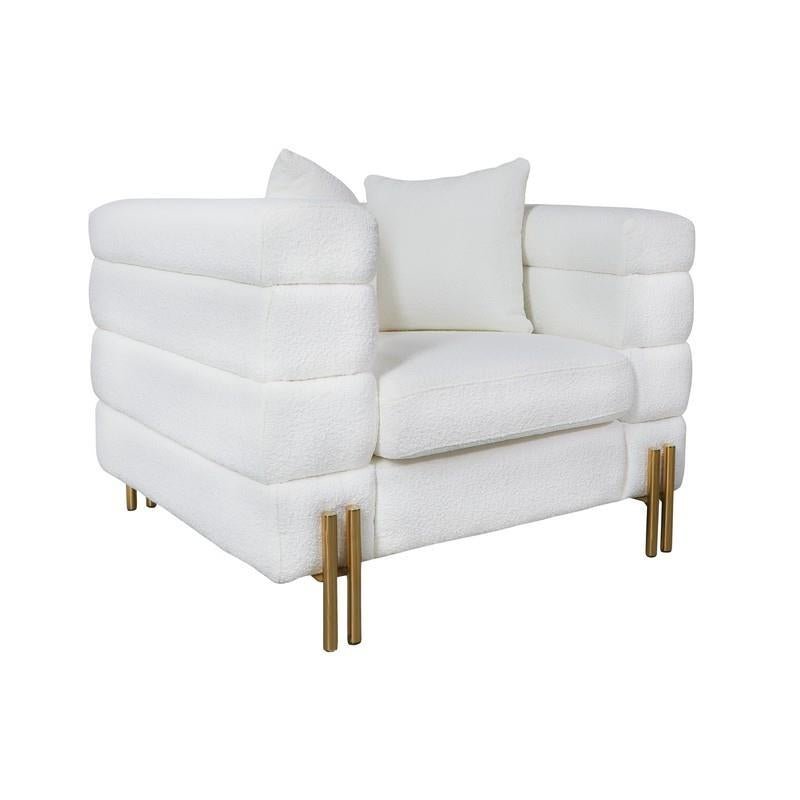 Modern white armchair with gold legs and plush cushions.