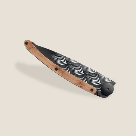 Stylish folding knife with geometric pattern and wooden handle, set on a beige background.