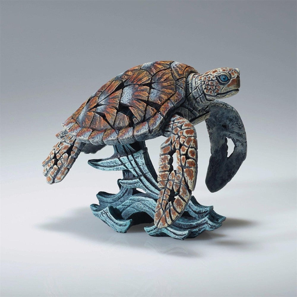 Intricate sculpture of a sea turtle on ocean waves.