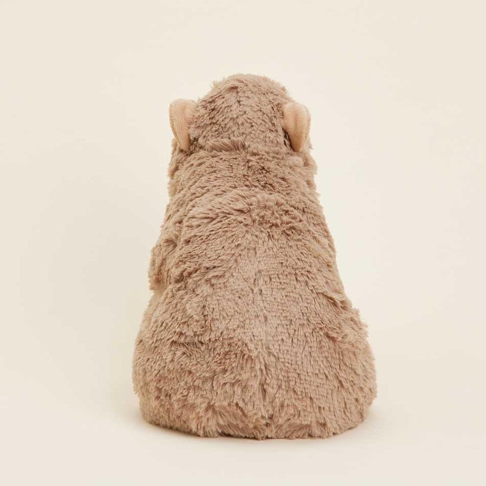 A fluffy plush bear facing away on a plain background.