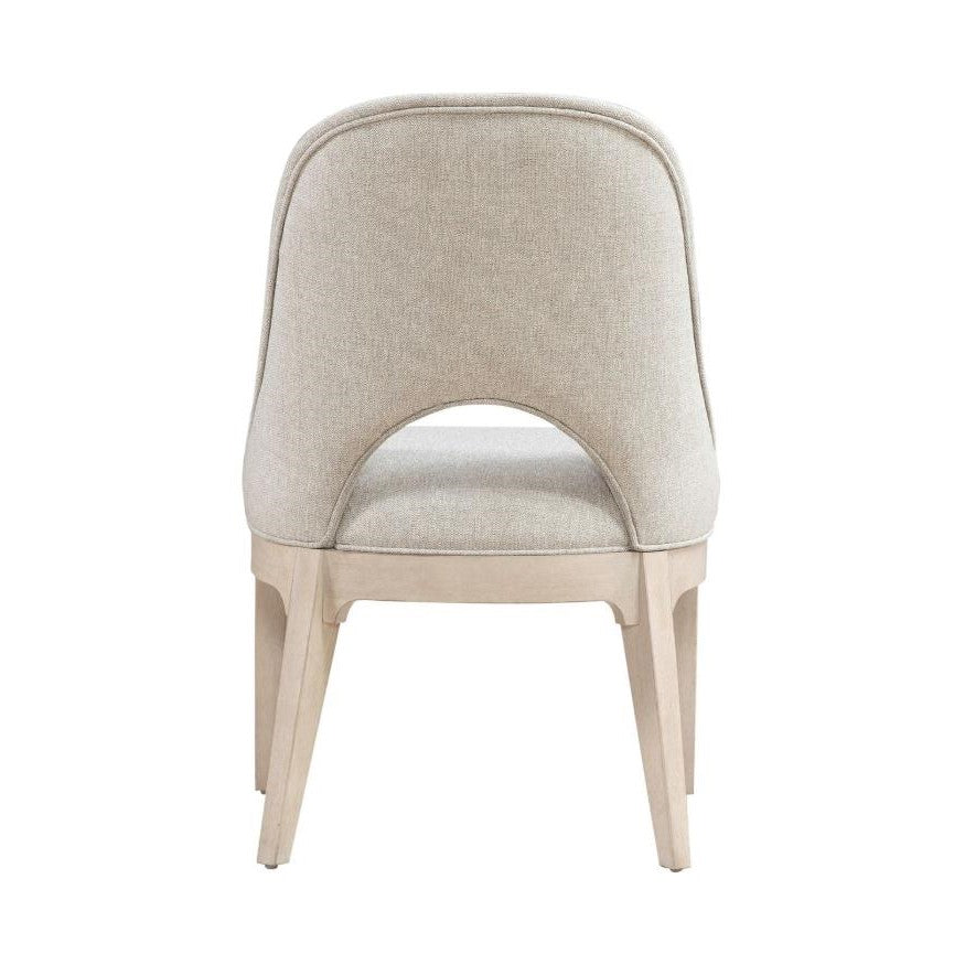 Beige upholstered chair with open back design.