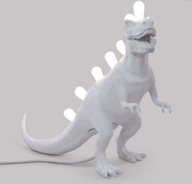White dinosaur lamp with glowing bulb spikes.