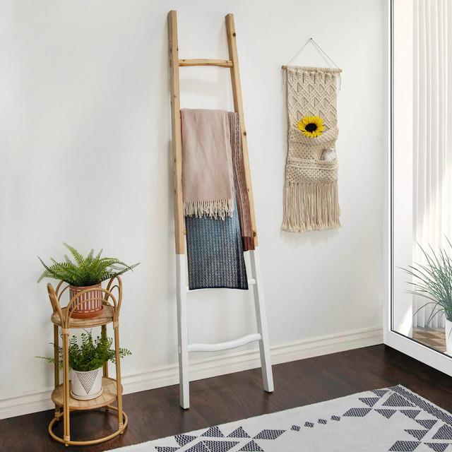 Wooden ladder, wall hanging, and plants in a cozy room corner.