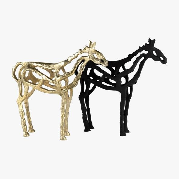 Two abstract giraffe sculptures, one gold and one black.