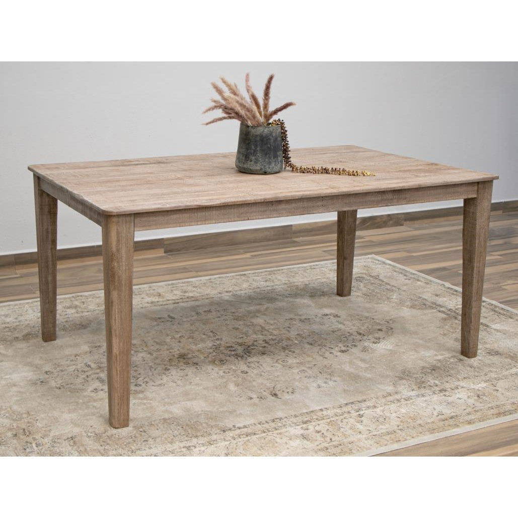 Wooden table with a vase of grass on a patterned rug.