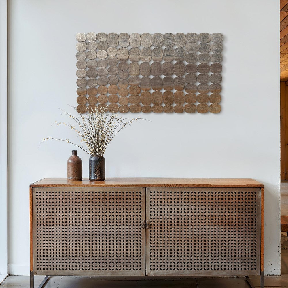 Wooden cabinet and vases below a textured metallic wall art.