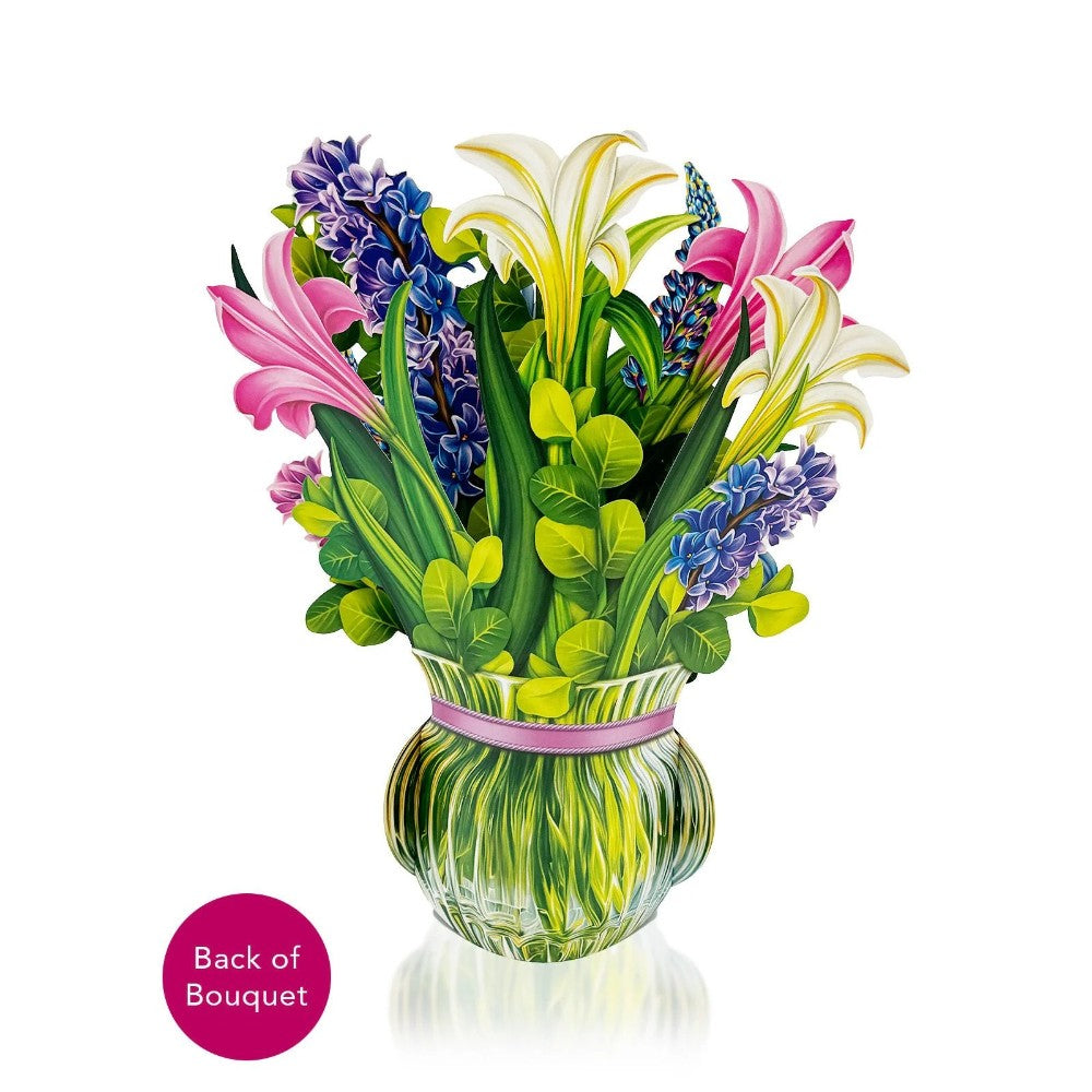 Colorful paper bouquet in a glass vase with lilies and hyacinths.