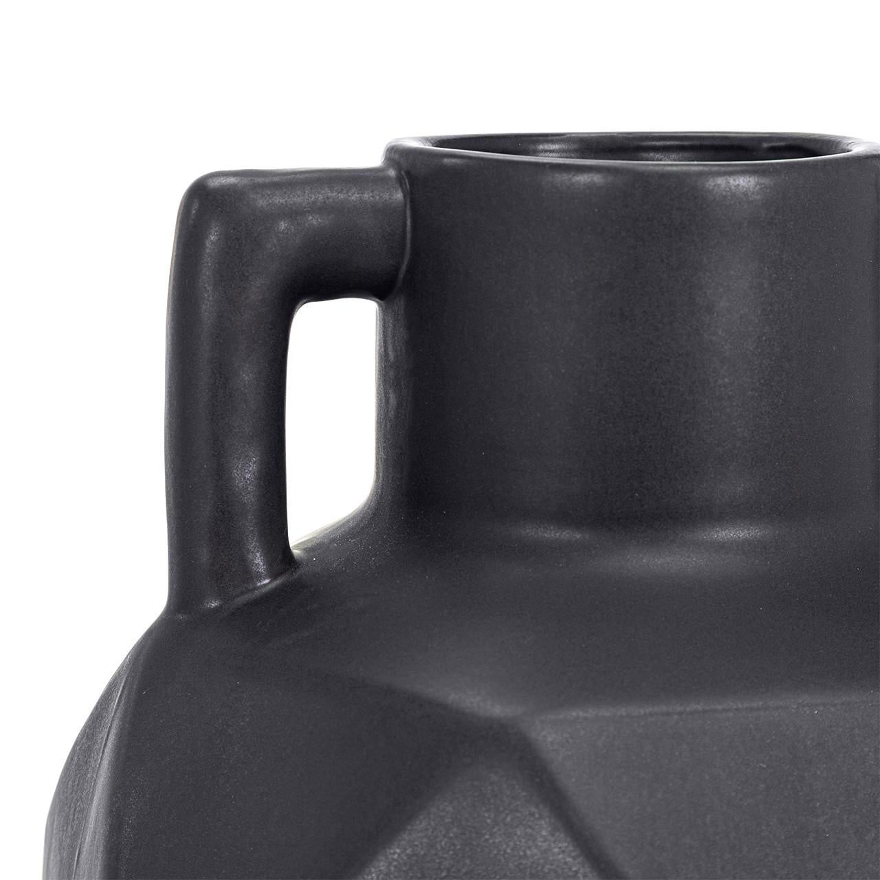 Dark ceramic jug with a geometric design and a handle on the left side.