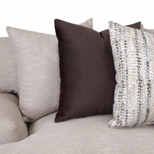 A cozy beige sofa with assorted cushions, including a black one and a patterned one.