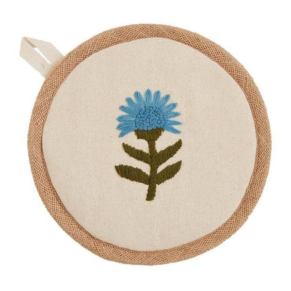 Beige circular coaster with a blue embroidered flower.