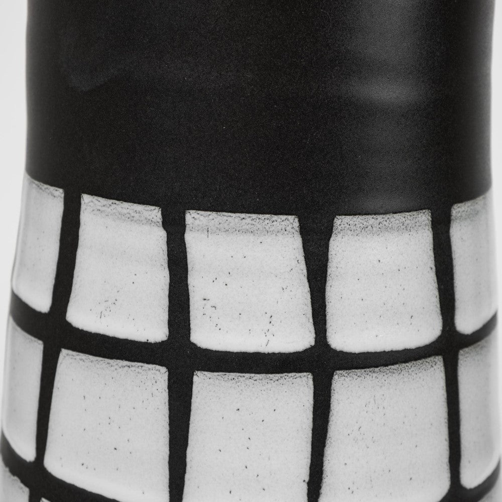 Black and white grid pattern on a ceramic surface.