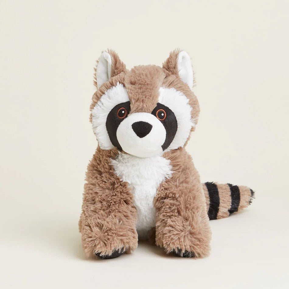 Cute plush raccoon toy with fluffy stripes on a beige background.