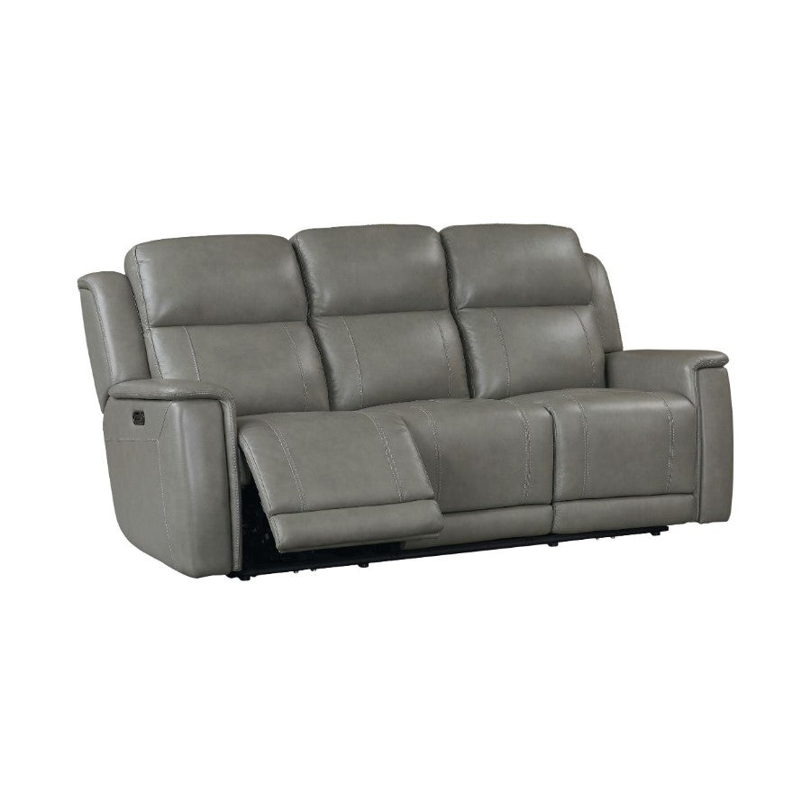 Gray reclining sofa with padded armrests and adjustable footrest.