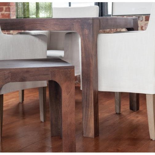 Wooden table with white chairs on a wooden floor.