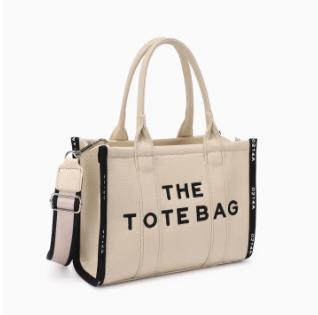 Beige tote bag with black accents and an adjustable shoulder strap.
