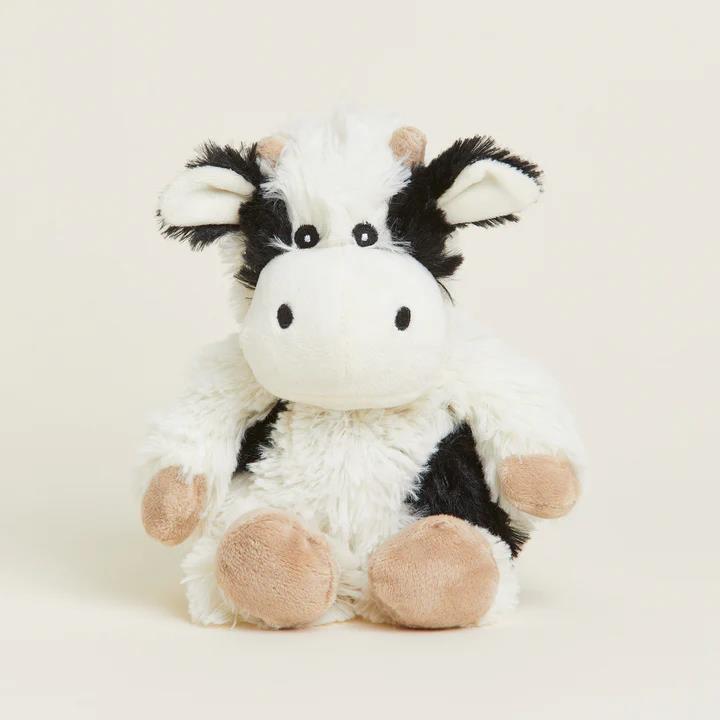 Fluffy cow plush toy with a cute face and black and white pattern.