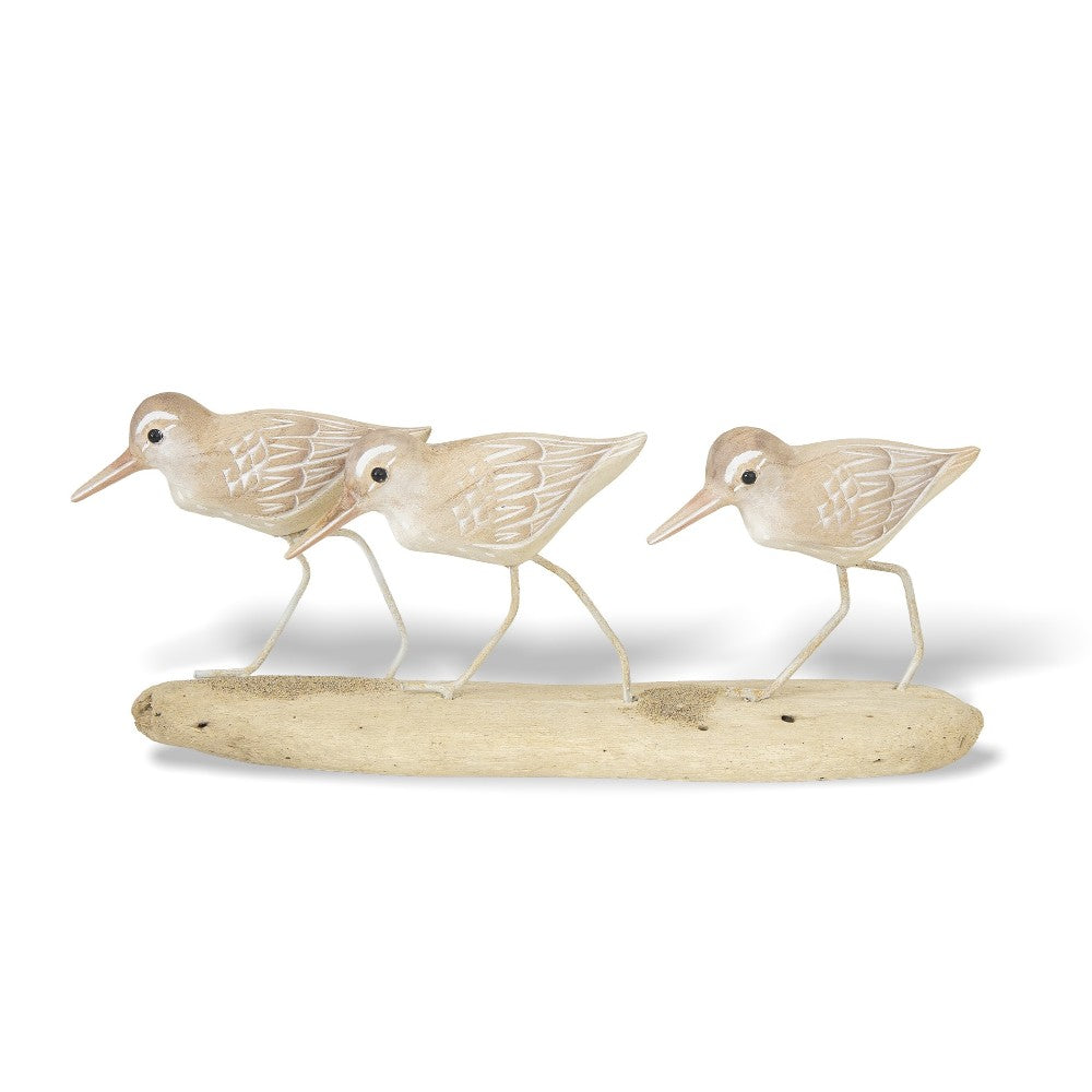 Three wooden bird sculptures on driftwood.