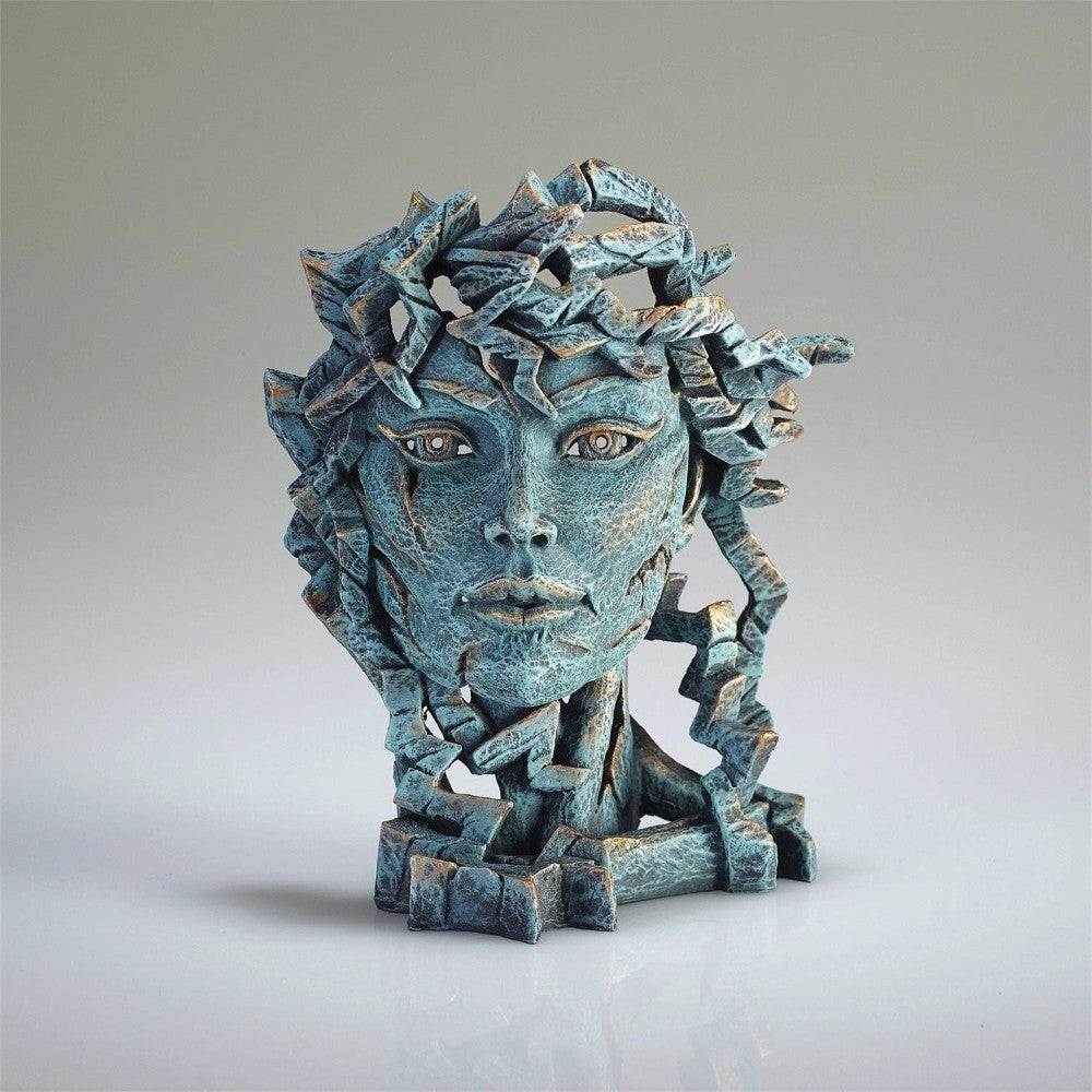 Fragmented teal sculpture of a woman's face with intricate details.