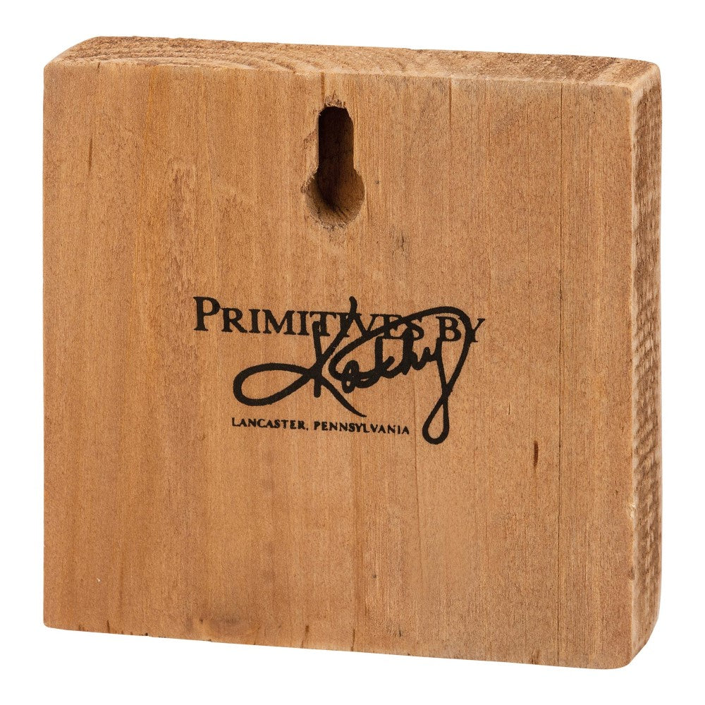 Wooden plaque with "Primitives by Kathy" inscription.