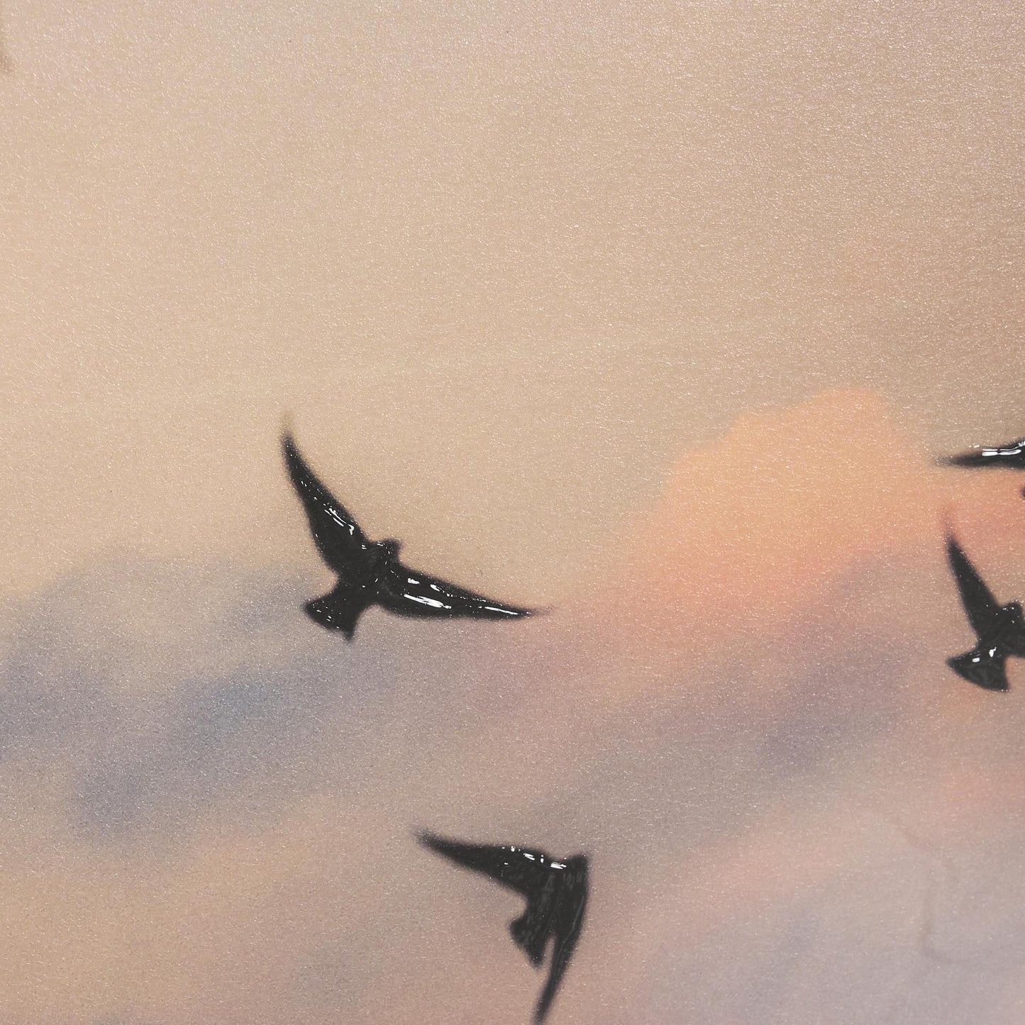 Bird silhouettes soaring in a pastel sunset sky.