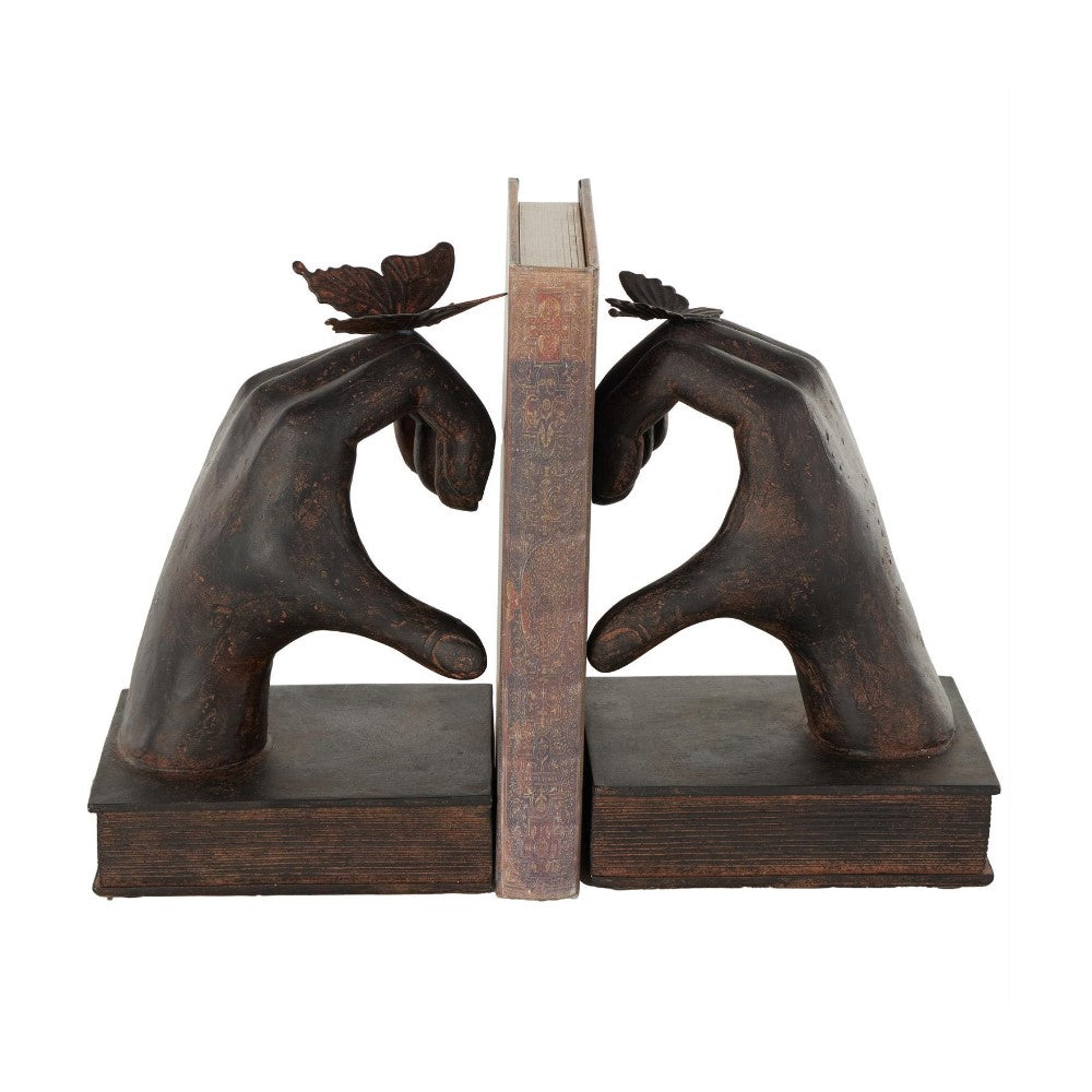 Two hand-shaped bookends with butterflies hold a book upright.