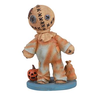 Patchwork doll with stitched head, next to a small pumpkin and sack.