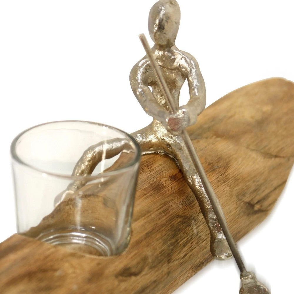 Metal figure rowing a wooden base with a glass holder.