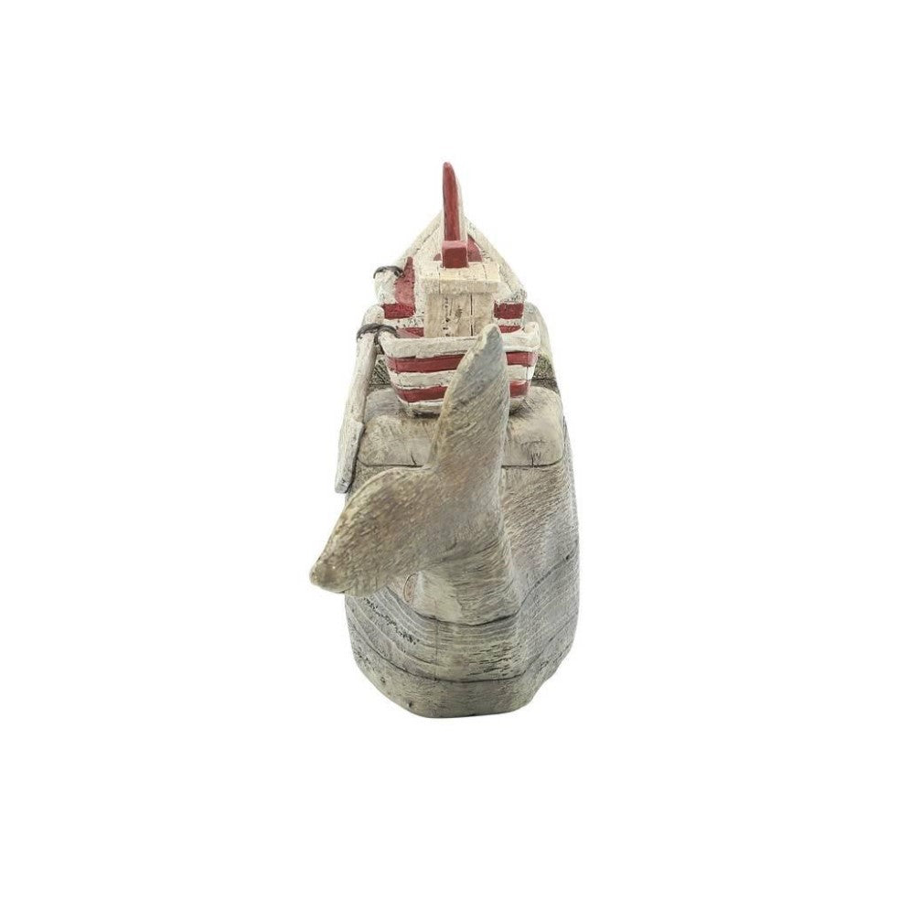 Wooden whale sculpture with a red striped ship on top.