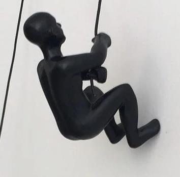 Black climber figurine scaling a wall on a rope.