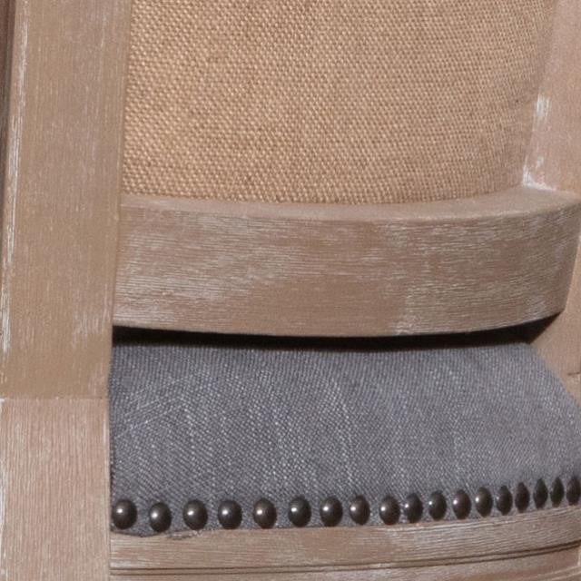 Close-up of a chair with weathered wood and upholstered fabric.
