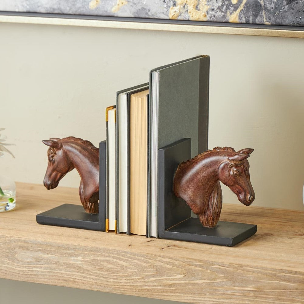 Books held by horse head bookends on a wooden shelf.
