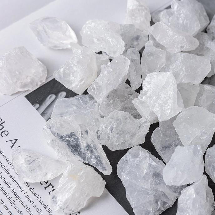 Clear quartz crystals scattered on a book page.