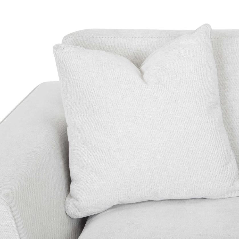 White cushion on a light-colored sofa.