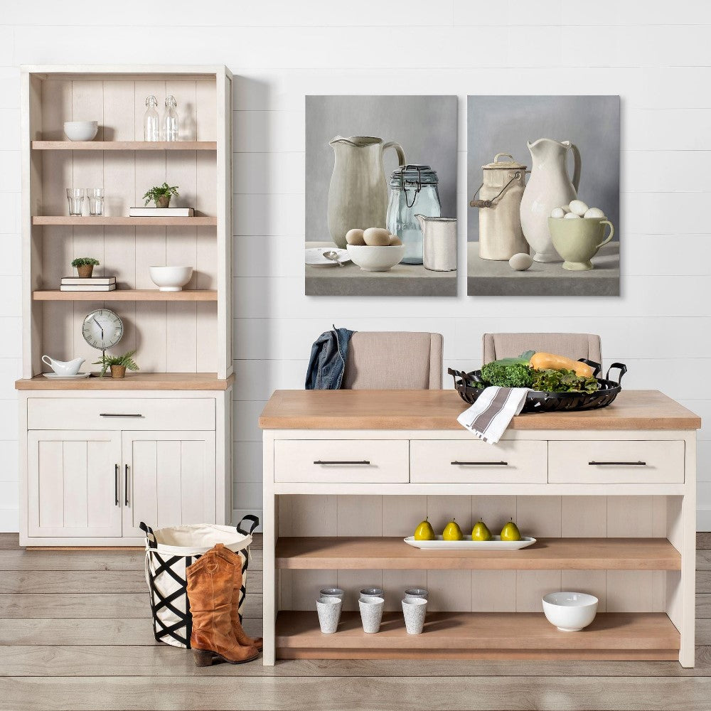 Rustic kitchen setup with art, greenery, and wooden furniture.