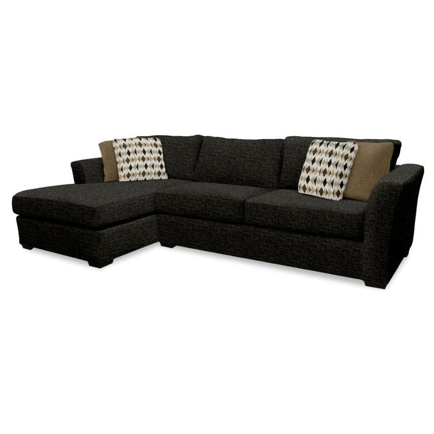 Dark sectional sofa with geometric and solid pillows.