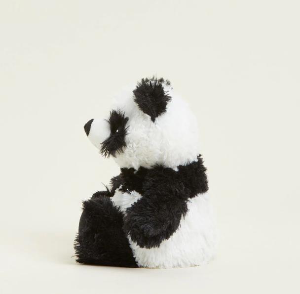 Side view of a fluffy panda plushie sitting on a plain background.