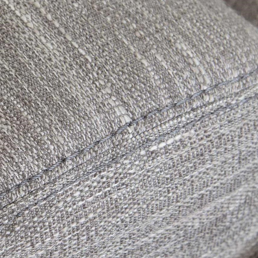 Close-up of gray textured fabric with visible stitching.