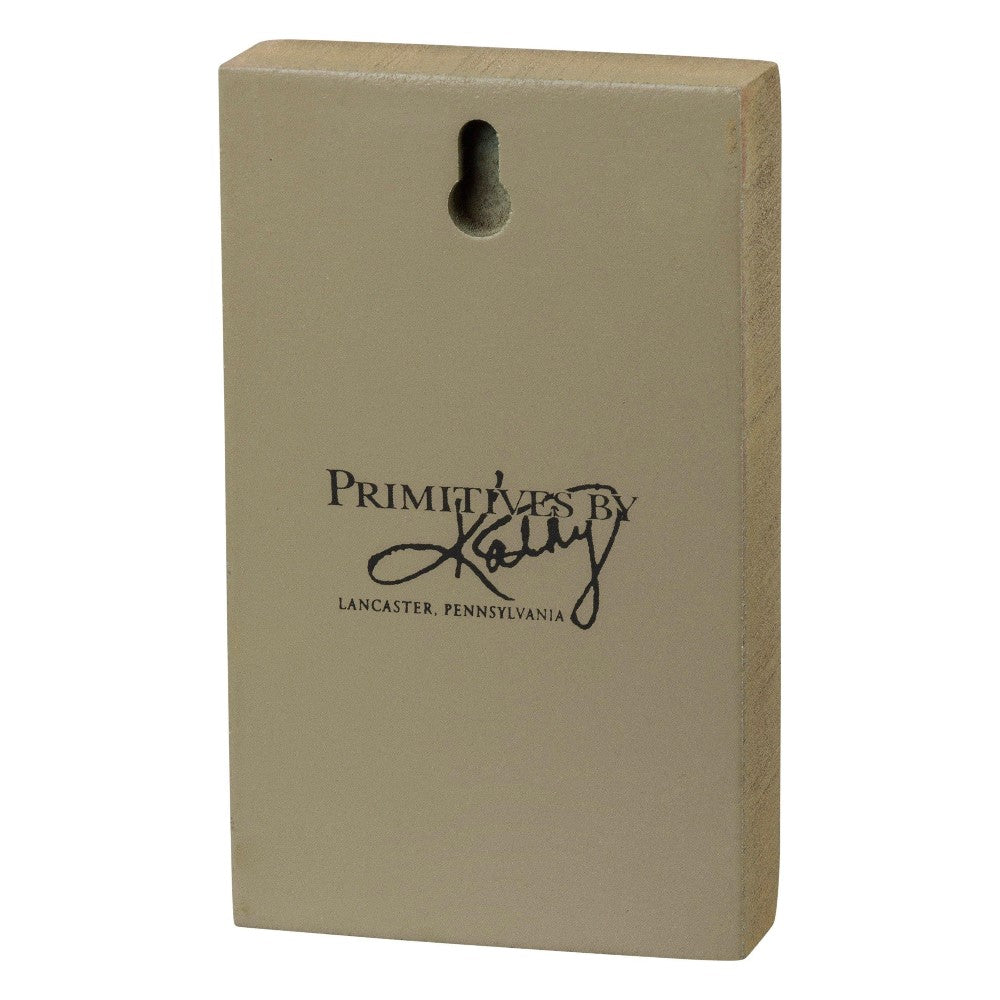 Wooden block with "Primitives by Kathy" printed on it.