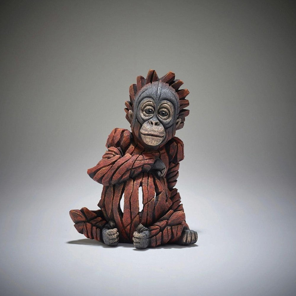 Sculpture of an adorable orangutan sitting playfully with a textured, fragmented design.