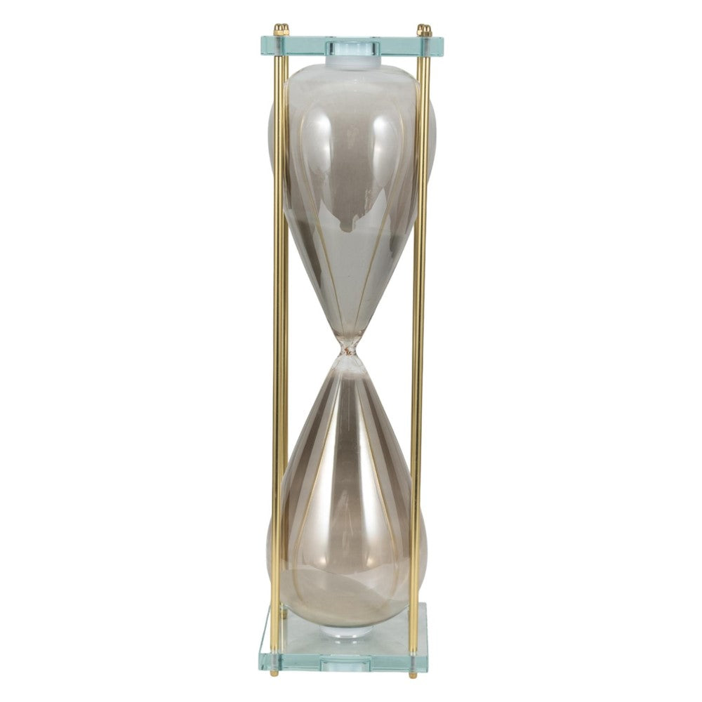 A glass hourglass with gold metal frame stands upright.