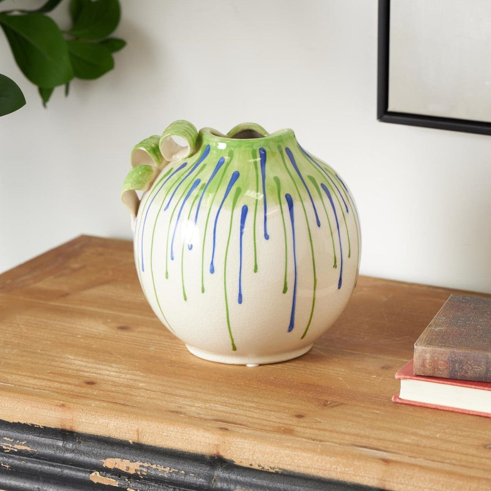 Colorful vase on a wooden table with books nearby.