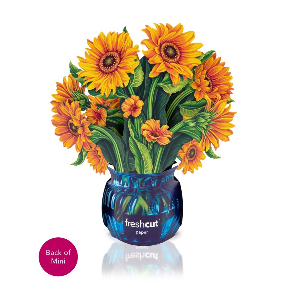 Vibrant paper sunflowers in a blue vase.
