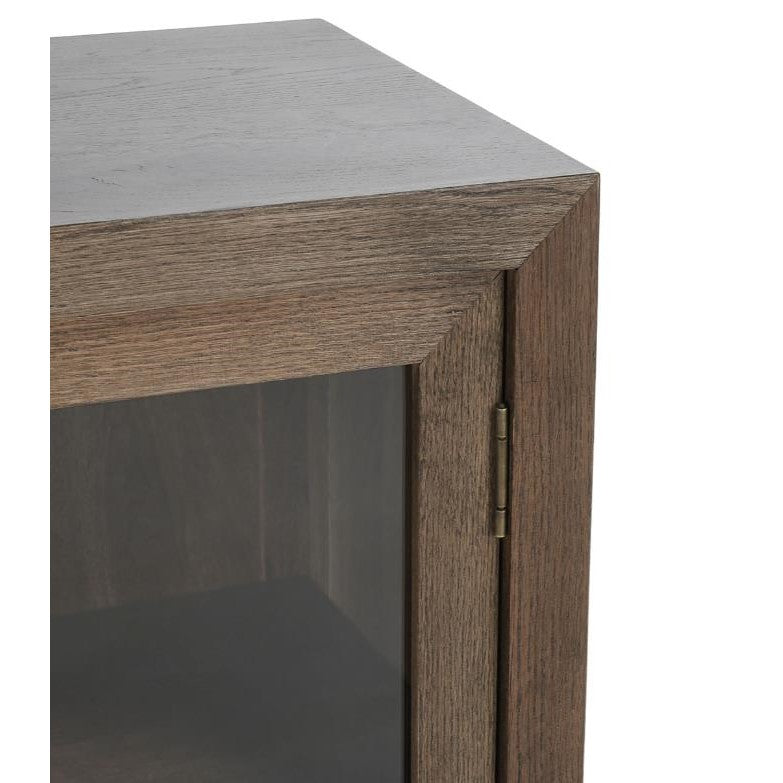 Corner of a wooden cabinet with a glass door.