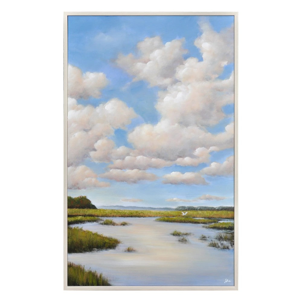 Blue sky, fluffy clouds, and serene marshland scene with calm water.