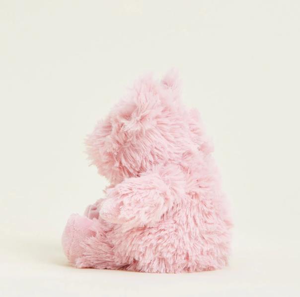 Fluffy pink toy bear sitting on a plain background.